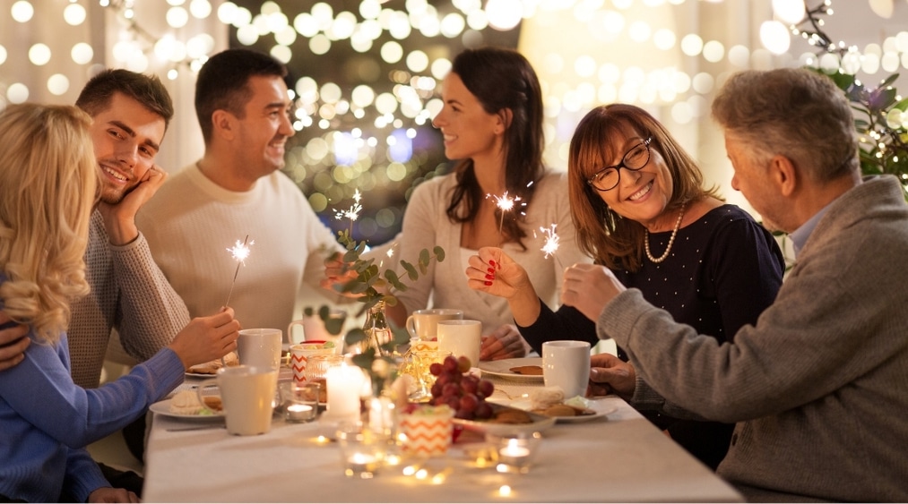 Family celebrating New Year at home with a clean and cozy dining space, enjoying a warm holiday moment together